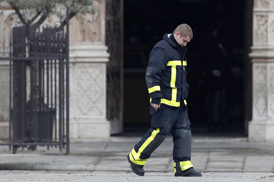Парижский пожарный у стен главного собора города утром 16 апреля.