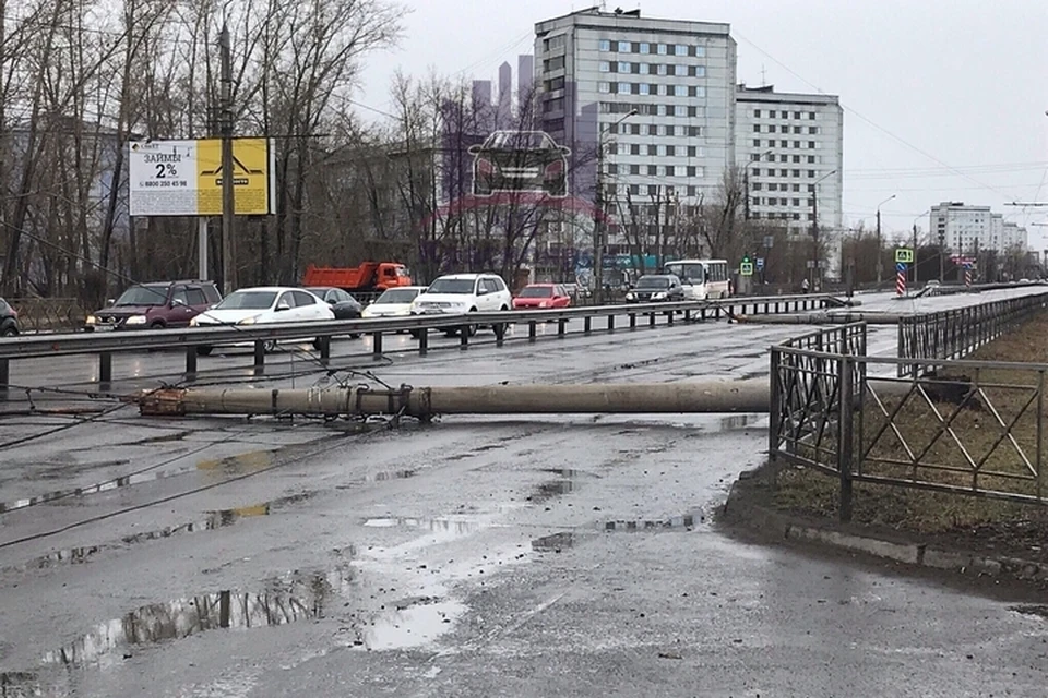 В Красноярске порывом ветра уронило два столба – прямо на проспект Металлургов. Фото "ЧП-Красноярск"
