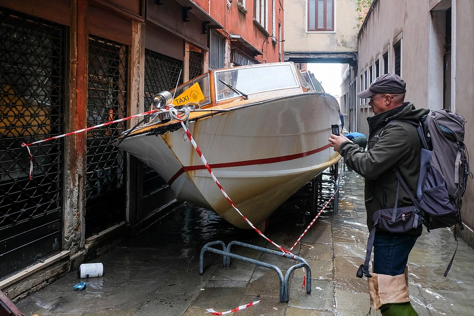 Поднявшаяся вода вынесла лодку на одну из узких улочек Венеции.