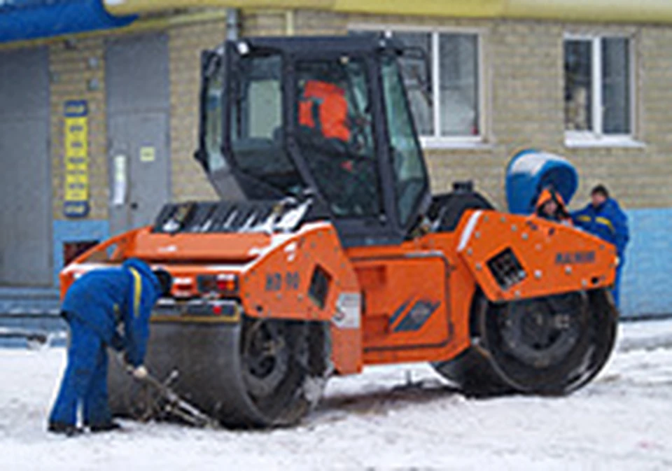 На снегу тяжелая дорожная техника буксует