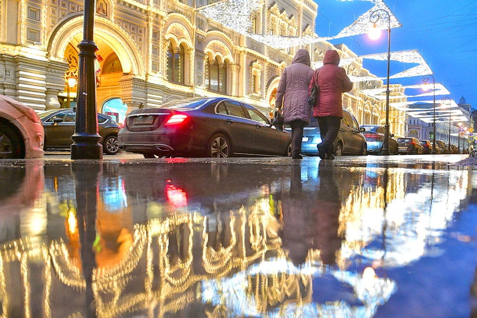 Новогодняя иллюминация в центре Москвы отражается в лужах, зимних холодов и снега в столице не было уже давно...