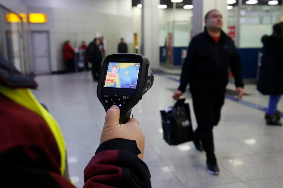 Проверка температурным сканером туристов, прилетающих из Китая, в Международном аэропорту Алматы в Казахстане.