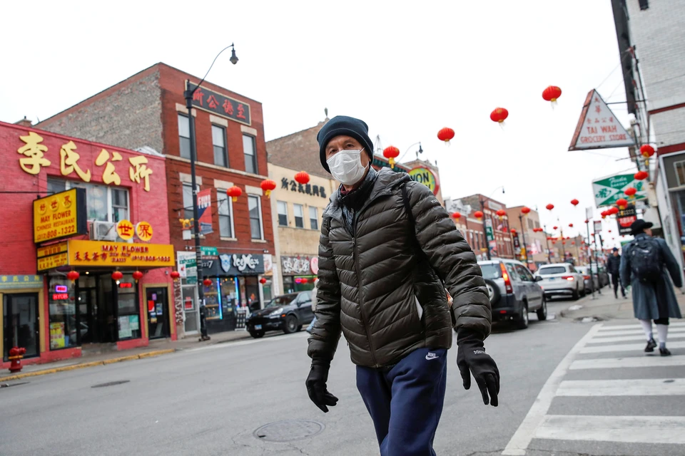 Прохожий в медицинской маске в китайском квартале Чикаго, США.