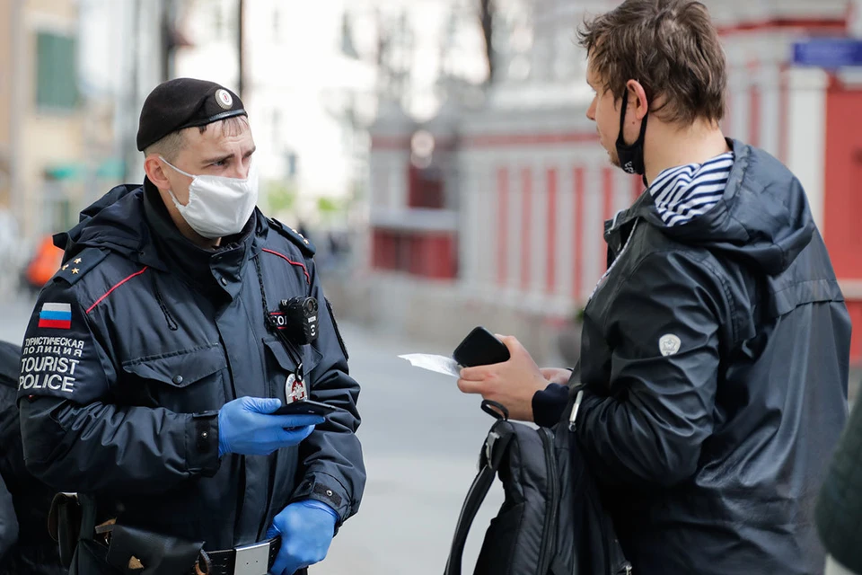 Мужчина и сотрудник полиции во время проверки цифрового пропуска в Москве. Фото: Михаил Метцель/ТАСС