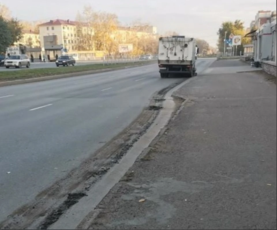 Пылеуборочная машина оставляла за собой след из мокрой грязи.