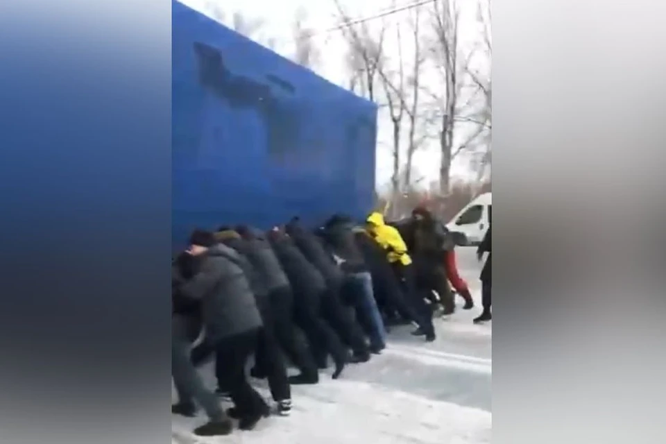Автомобилисты на руках вынесли фуру, перекрывшую движение. Фото: стоп-кадр