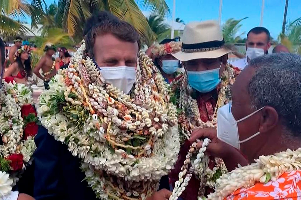 Один за другим на Макрона стали вещать венки из цветов, что является символом почета и уважения во Французской Полинезии.