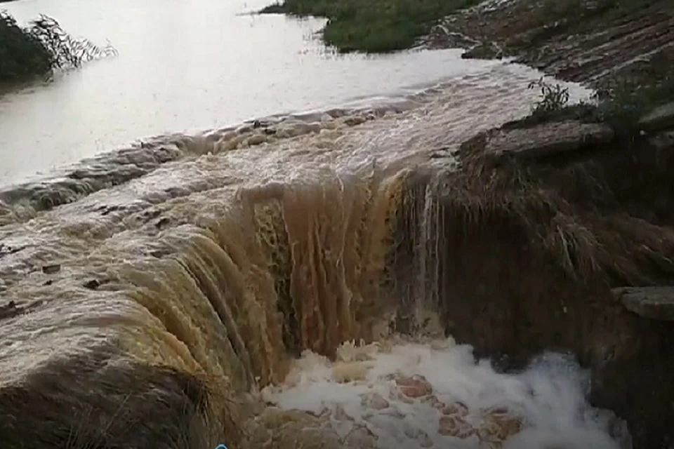Вода из переполненного ставка под Керчью устремилась в реку, бегущую в сторону городских окраин. Фото: скрин из видео Елены Якимовой.