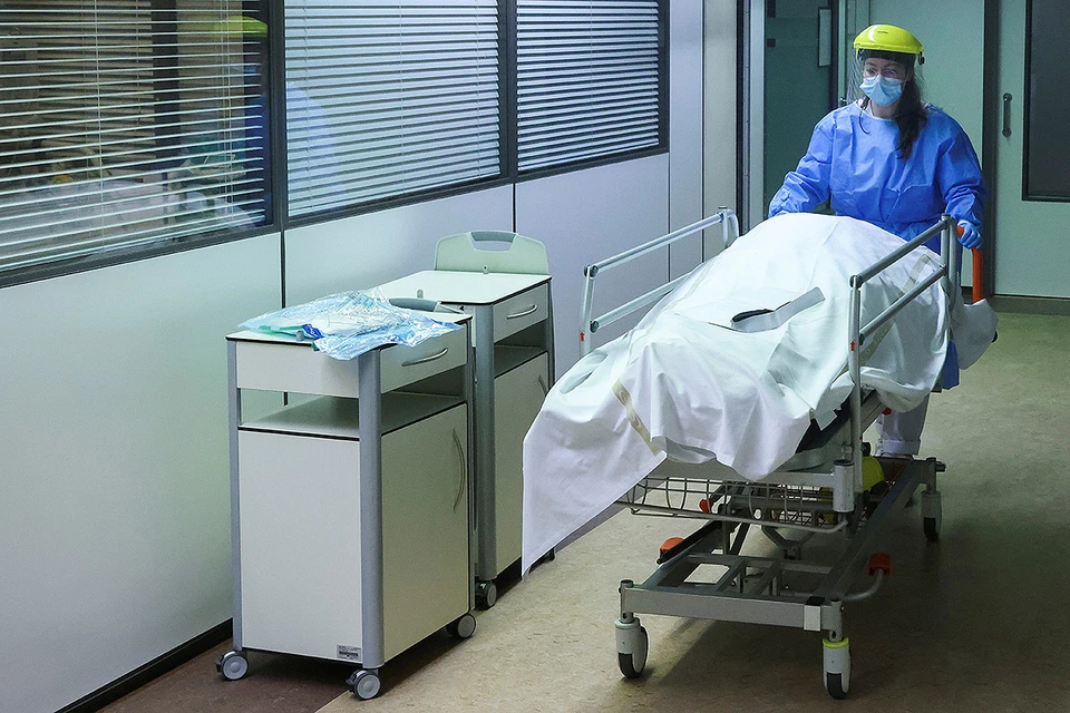 Медик везет труп пациента, скончавшегося от последствий ковида, в клинике Антверпена, Бельгия.