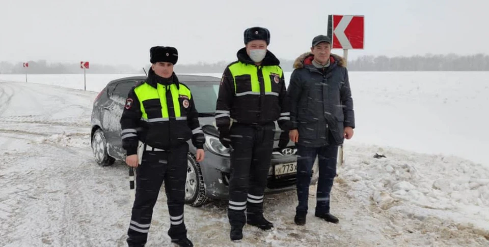 Автоинспекторы с водителем, которому они помогли.