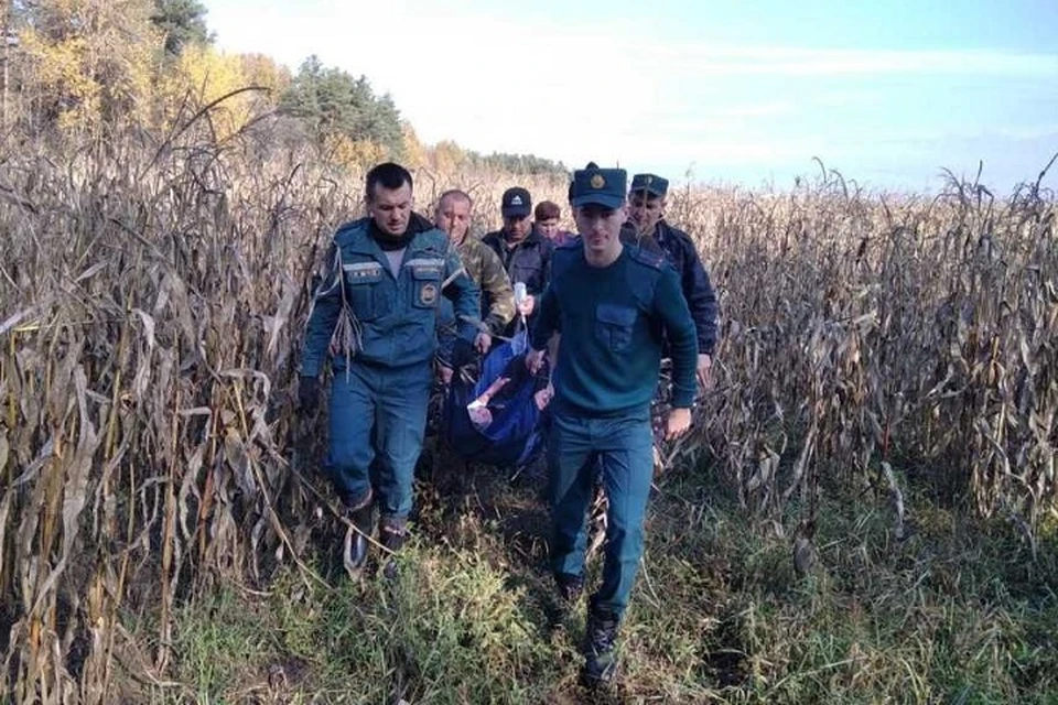 Спасатели выносят женщину с кукурузного поля. Фото: МЧС Беларуси