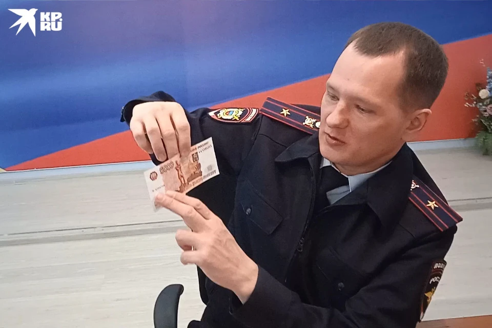Поддельную купюру демонстрирует майор полиции Павел Мазур. Получить от кого-то такую фальшивку будет обидно - убытки вам не возместят.