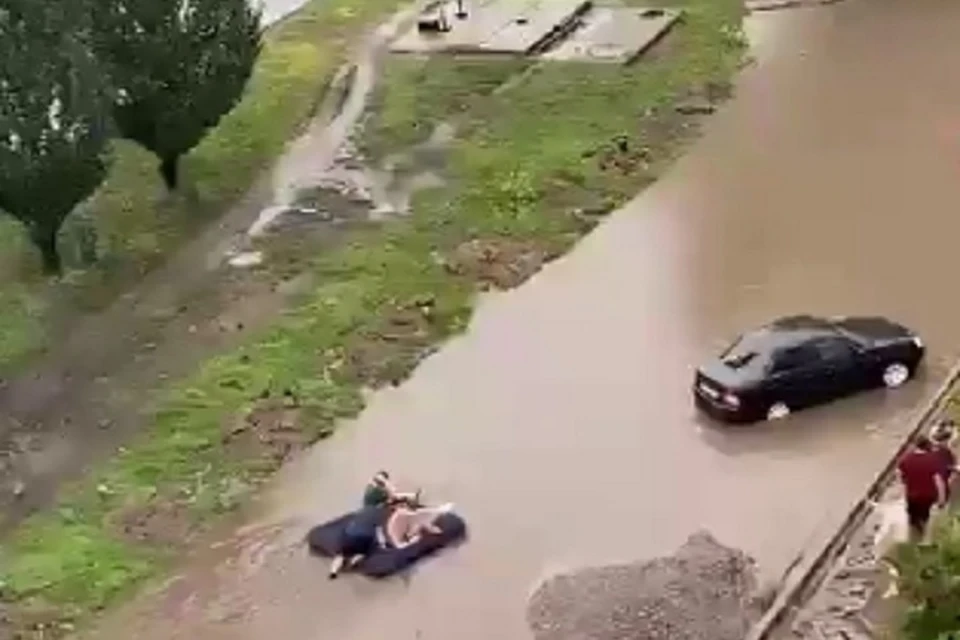 Вооружившись веслом мужчины преодолевают путь по улице. Фото: скриншот видео