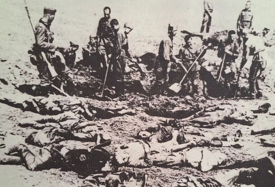 Немецкие оккупанты заставляли военнопленных убирать трупы погибших советских солдат. Снимок сделан 26 июля 1942 года.