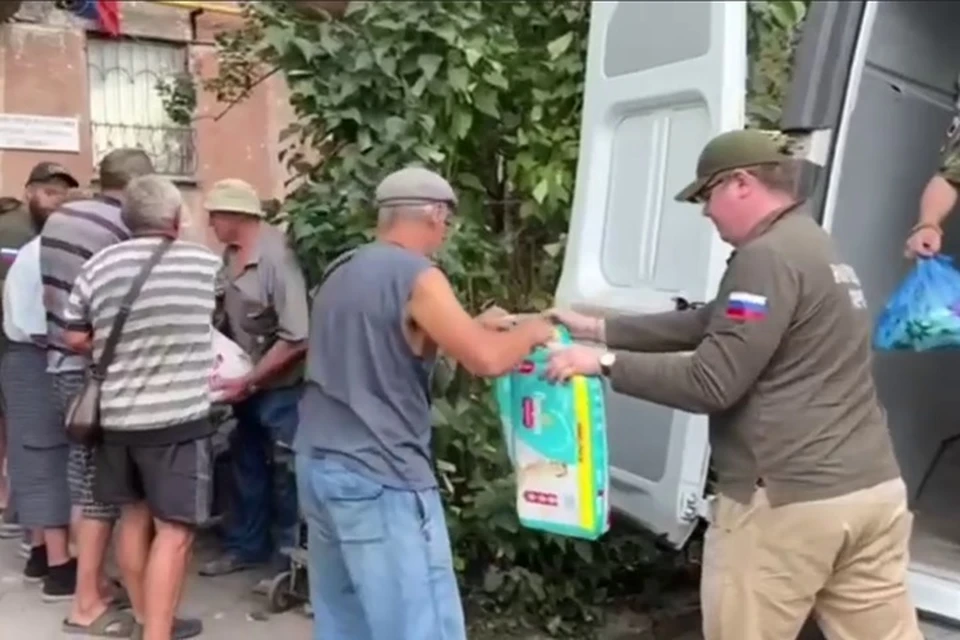 В Попаснянском районе порядка 100 жителей поврежденной от боевых действий многоэтажки получили гуманитарную помощь. Фото - скрин из видео Народного Фронта ЛНР