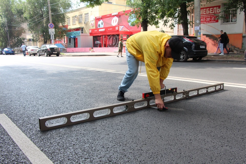 Активисты проверяют дорожное покрытие.