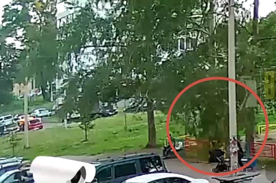 Мужчина сидел на скамейке возле детской площадки, а рядом с ним в коляске находился ребенок.