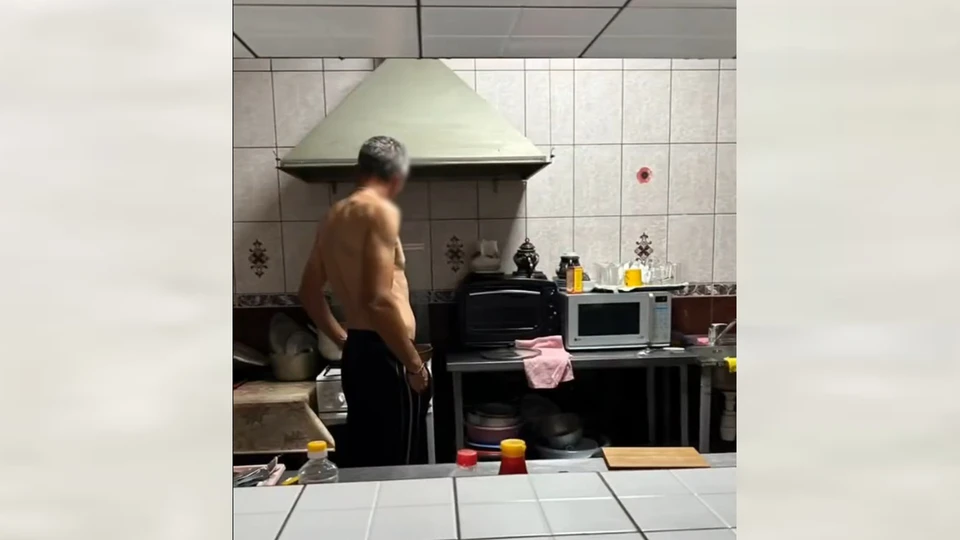 Мужчина без спецодежды готовил на кухне кафе. Фото: скриншот видео
