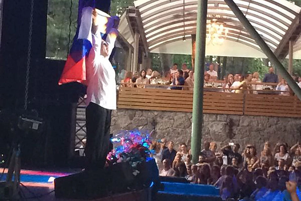 Зрители, коих был полон зал, встретили артиста овациями, когда он появился на сцене, гордо неся над собой российский флаг