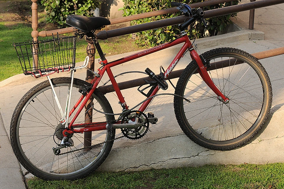 Один из лучших вариантов крепления велосипеда: раму удерживает замок, а колеса - металлический трос.