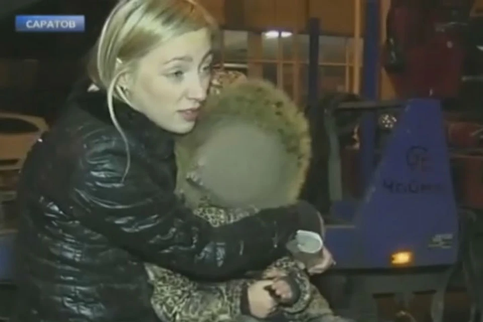Под конец фееричного шоу мадам уселась с малышкой на капот, чтобы машину не забрали на штрафстоянку. Фото: скриншот видео НТВ.