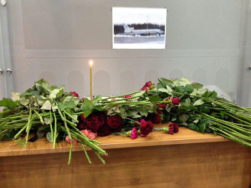 У небольшой часовни в аэропорту установили стол, повесили фотографию разбившегося лайнера и поставили свечи